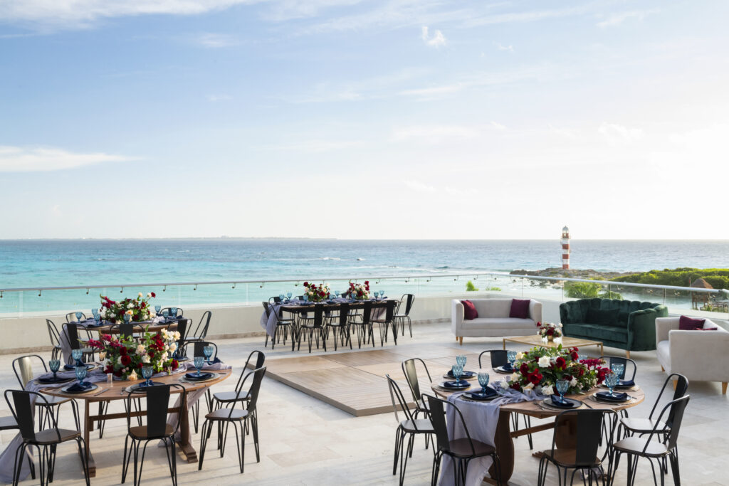 rooftop reception with tables and chairs, flowers on tables