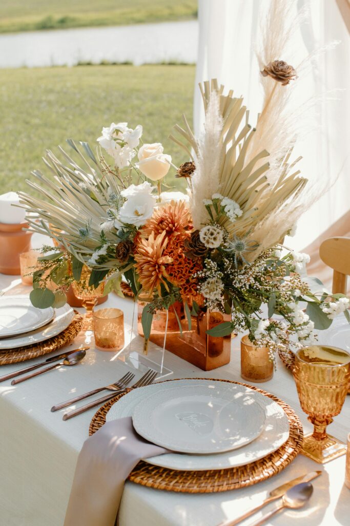 tropical orange and white and brown flowers, gold, orange, brown  table setting.