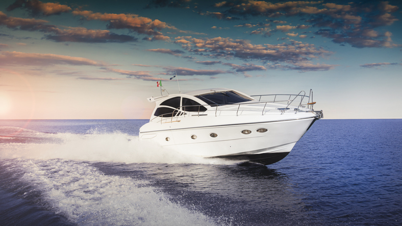 Luxurious motorboat sailing the sea at sunset. Blue waters, white cruiser