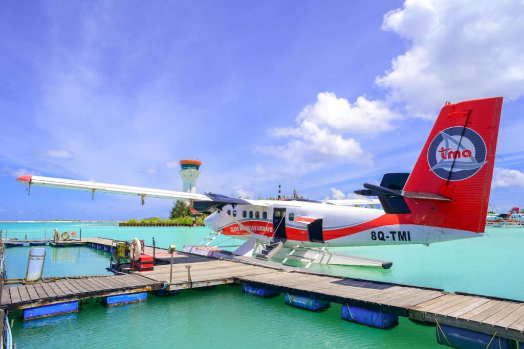 small red, white and blue airplane on a deck