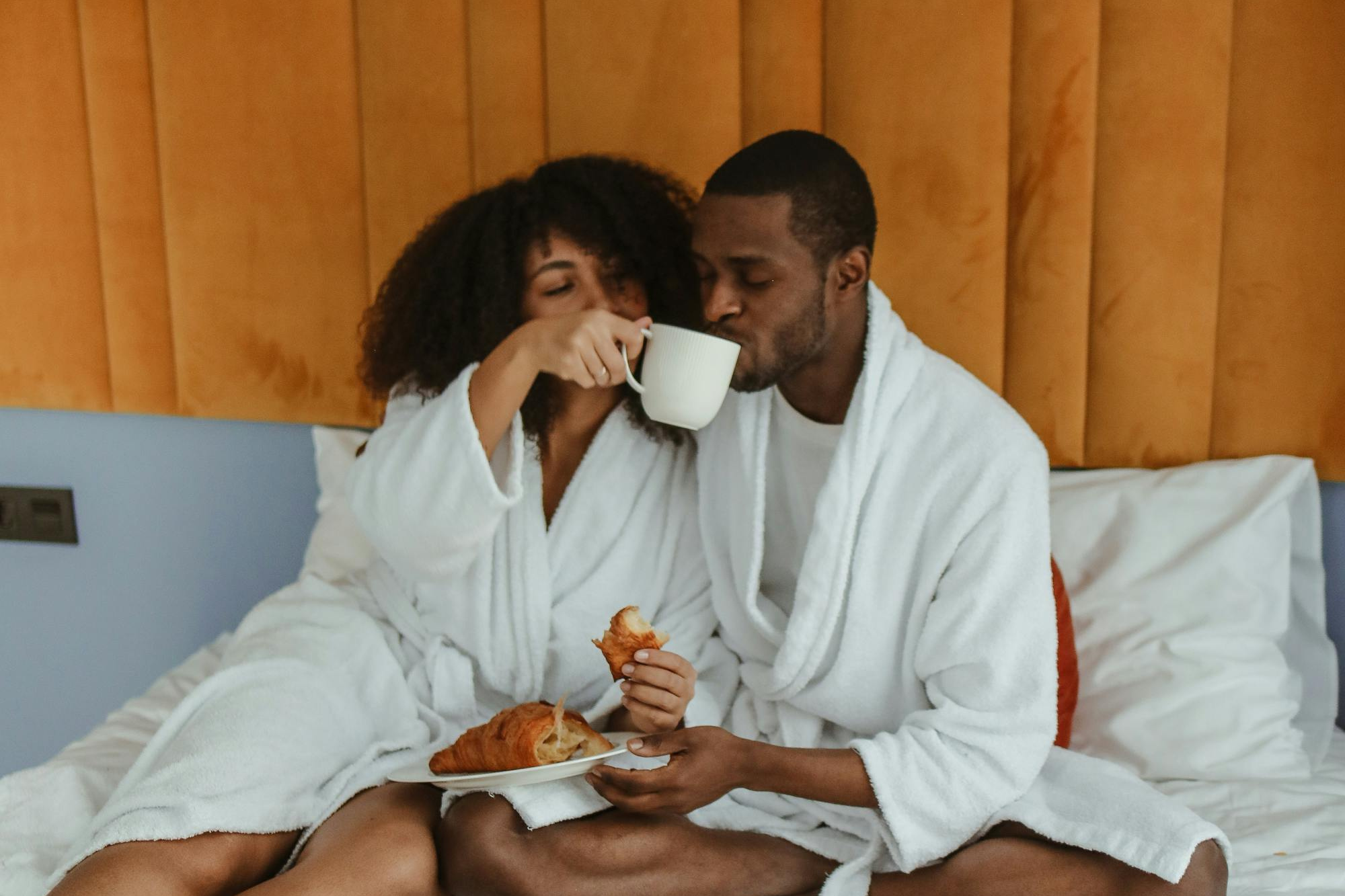 couple enjoying breakfast in bed, honeymoon