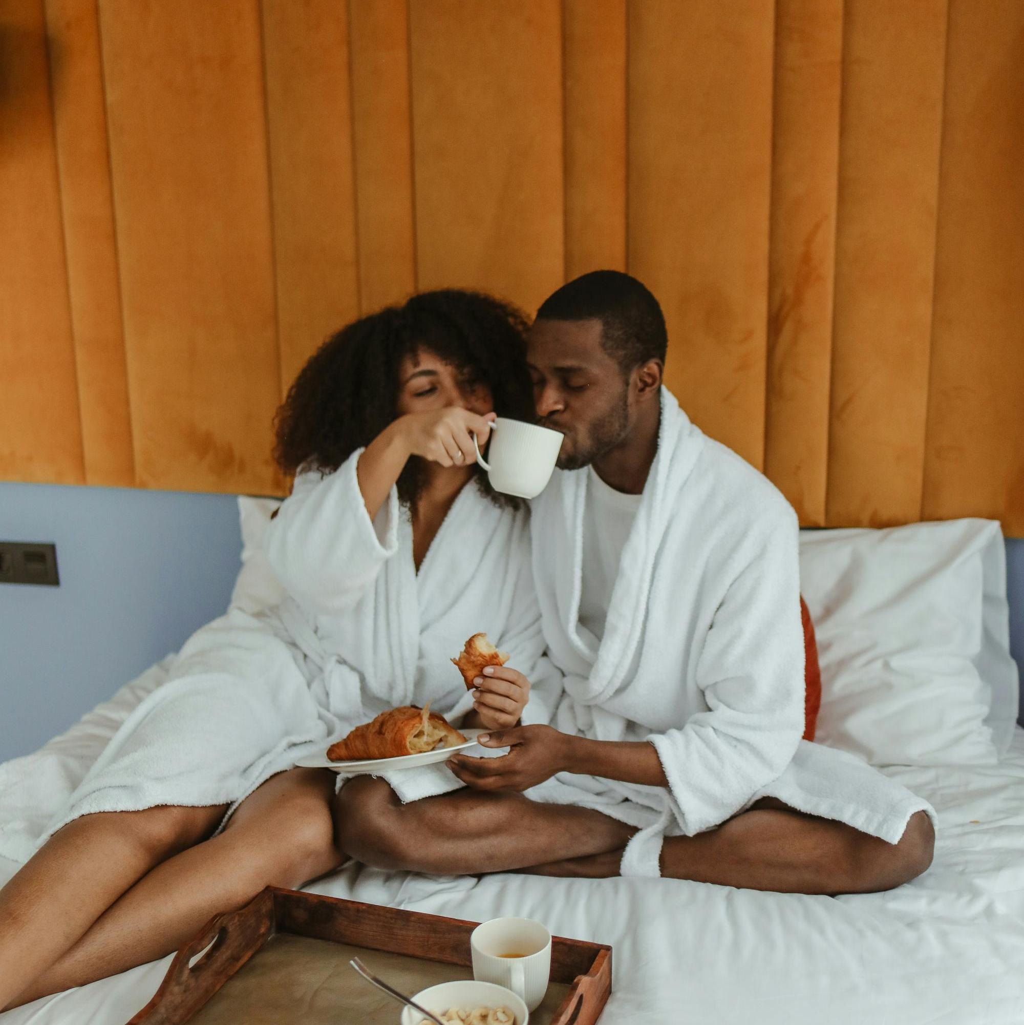 couple enjoying breakfast in bed, honeymoon