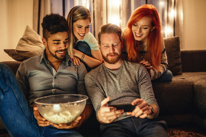 Men and women looking at phone smiling